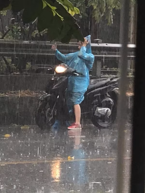 Cụ thể, bức ảnh chụp trộm một cô nàng đang tranh thủ "tự sướng" trước cơn mưa rào thổi tan cái nắng nóng gay gắt của Thủ Đô đã được chia sẻ rộng rãi trên mạng xã hội.