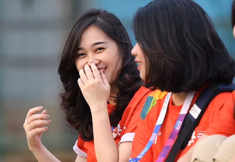 Cảm xúc ngượng ngùng của các cô gái tình nguyện viên sau khi phát hiện ống kính của phóng viên đang hướng về mình.