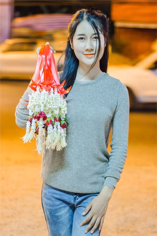 Sau một hồi truy tìm danh tính tích cực, cư dân mạng đã tra ra được cô gái bán hoa khô dạo trên đường phố Thái Lan này có tên là Parkum WahRuk. Cô nàng sinh ra và lớn lên tỉnh Ubon Ratchathani, Thái Lan.