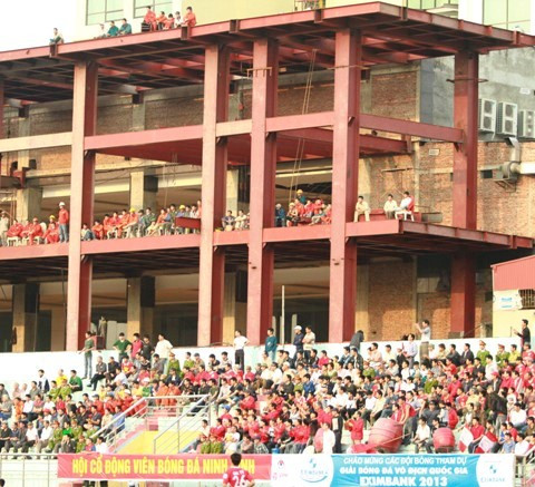Sân Ninh Bình nằm lọt thỏm giữa các tòa nhà chung cư nên việc các công nhân và NHM thường xuyên trèo lên những tòa nhà đang thi công này để xem bóng đá. Ảnh: Bongdaplus.