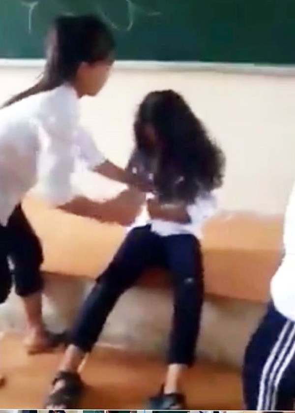 Không chỉ đánh đấm bằng chân tay, nữ sinh trên còn bị các bạn cùng lớp xé áo làm nhục trước mặt nhiều người.