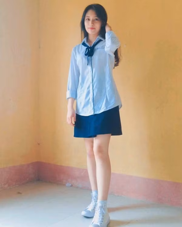 Hình ảnh những nữ sinh mặc váy đồng phục cùng đôi giày thể thao quả thực luôn dễ thu hút mọi ánh nhìn khi toát ra vẻ đẹp trong sáng nhưng không kém phần quyến rũ. Mới đây, trên mạng xã hội xuất hiện bức ảnh nữ sinh lớp 12 có mái tóc dài, gương mặt mộc chỉ điểm thêm chút son môi phớt hồng đứng góc lớp khiến nhiều dân mạng "thấy là yêu luôn". Ảnh trong bài: Facebook nhân vật.