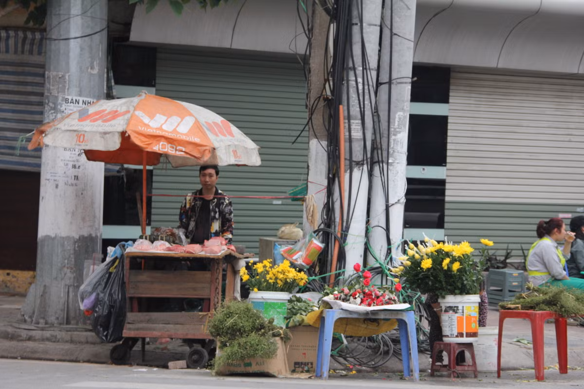 Ở một góc chợ cóc Đặng Trần Côn, hàng hoa và hàng thịt vẫn bán để phục vụ người dân cuối chiều 30 Tết.