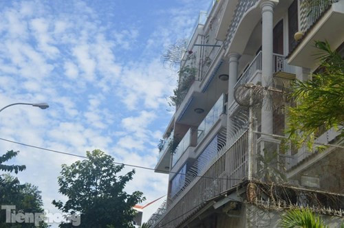 Mặt tiền tầng trên cùng được gắn đá và lan can sắt hàn kín mít.