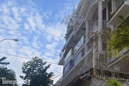 Mặt tiền tầng trên cùng được gắn đá và lan can sắt hàn kín mít.