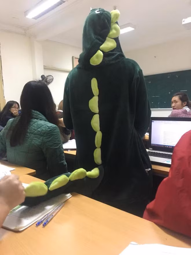 Thay vì mặc áo bông hay quàng khăn len... với bộ đồ khủng long xanh, cô gái này đã khiến cho mình trở nên rất nổi bật trong lớp học.