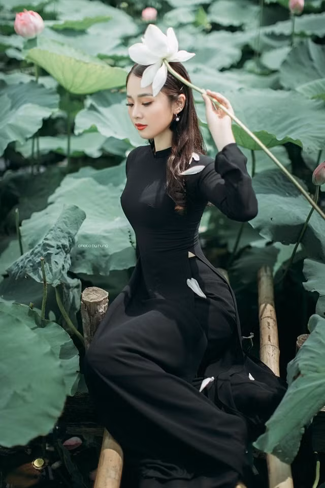 Giống như nhiều bộ ảnh khác, anh Hùng và mẫu ảnh cũng lựa chọn áo dài chụp cùng hoa sen. Tuy nhiên điểm độc đáo của bộ ảnh này lại ở bộ áo dài màu đen tuyền và bông hoa sen trắng nổi bật thay vì áo dài trắng như thông lệ.