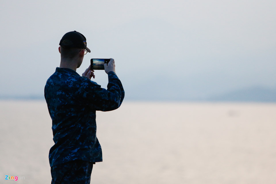 Một thủy thủ chụp lại phong cảnh nhìn từ boong tàu tại Đà Nẵng. Trong chuyến thăm, các sĩ quan và thủy thủ đoàn sẽ tham gia một số hoạt động cộng đồng tại thành phố biển như biểu diễn ca nhạc, giao lưu thể thao, thăm và giao lưu tại Làng trẻ em SOS, Trung tâm Bảo trợ nạn nhân chất độc da cam...