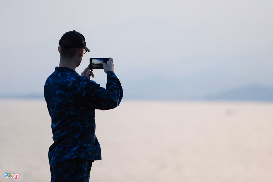 Một thủy thủ chụp lại phong cảnh nhìn từ boong tàu tại Đà Nẵng. Trong chuyến thăm, các sĩ quan và thủy thủ đoàn sẽ tham gia một số hoạt động cộng đồng tại thành phố biển như biểu diễn ca nhạc, giao lưu thể thao, thăm và giao lưu tại Làng trẻ em SOS, Trung tâm Bảo trợ nạn nhân chất độc da cam...