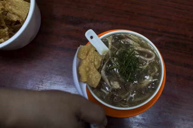 Súp rắn được phủ bằng lá chanh xắt nhỏ và hoành thánh chiên.