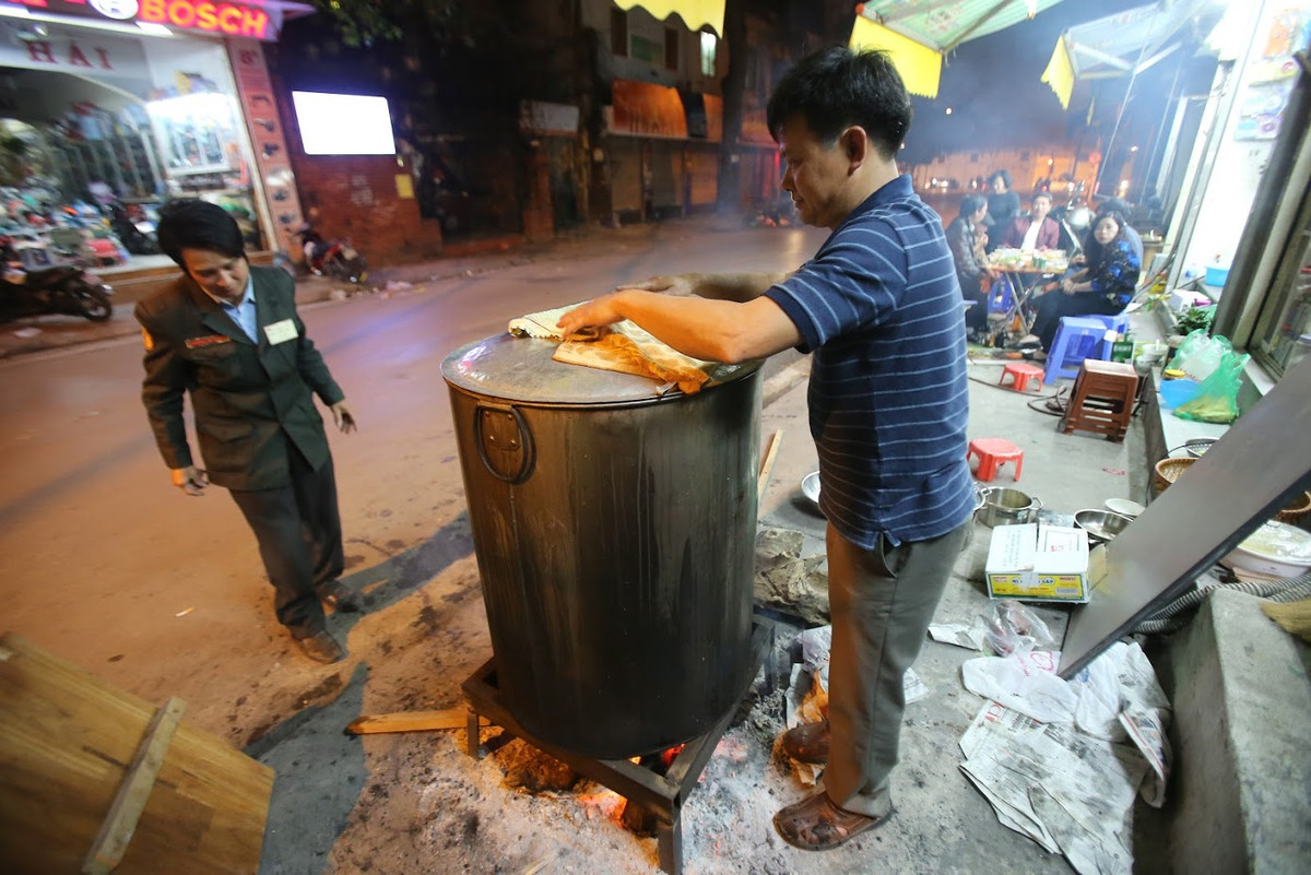 Trong con ngõ nhỏ số 32 phố Đội Cấn - Ba Đình, bác Hoàng Thanh Cúc cũng đang bận rộn vừa bán hàng xôi, vừa trông nồi bánh chưng của cả khu. Ánh lửa đỏ dập dìu cùng khói bốc nghi ngút từ nồi bánh chưng cũng khiến không khí ngày Tết càng thêm rạo rực.