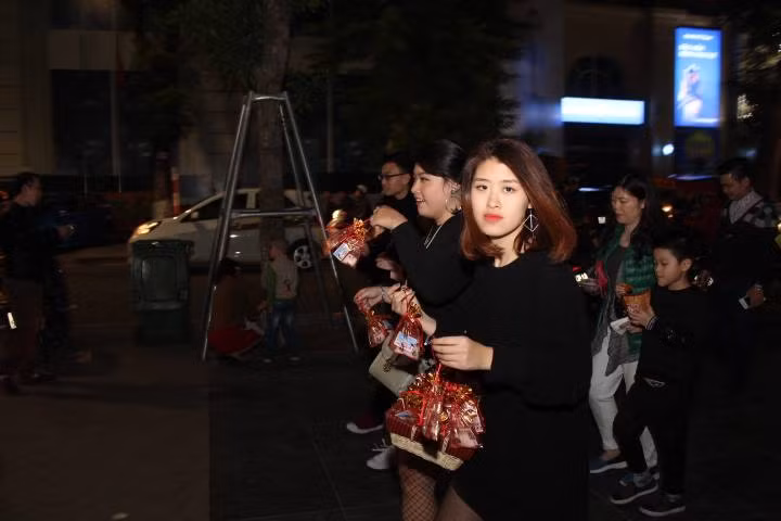 Một cô bạn gái xinh đẹp tranh thủ thời gian đi bán muối tại khu vực Hồ Hoàn Kiếm Hà Nội.