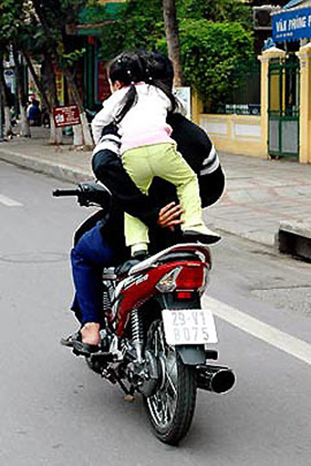 Hình ảnh người bố vừa đi xe, vừa đỡ con đang đùa nghịch khiến nhiều người giật mình.