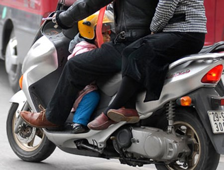 Dường như đặt con ngồi vào phần để chân của xe ga là phương pháp an toàn nhất của các bậc cha mẹ?