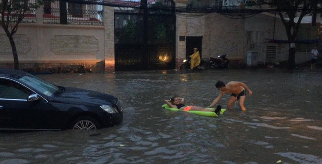 Còn trước đó, một đôi bạn trẻ người nước ngoài đã tranh thủ phố Hà Nội ngập đã biến nó thành bể bơi khi mang phao ra phố để nằm hưởng thụ.