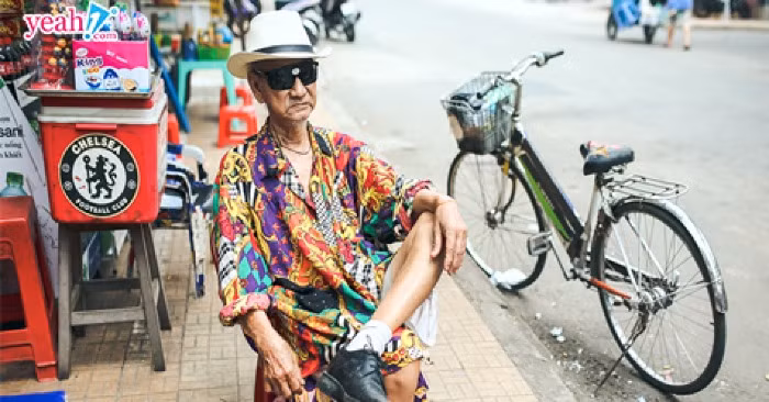 Cụ già bán vé số có phong cách cực chất nói trên có tên là Đỗ Trọng Đình, 92 tuổi, đang sinh sống tại Châu Đốc. Phong thái tự tin trong trang phục quần đùi, áo sơ mi sặc sỡ của cụ ông khiến không ít người phải liếc mắt nhìn mỗi khi đi ngang qua. Ảnh: Yeah1.