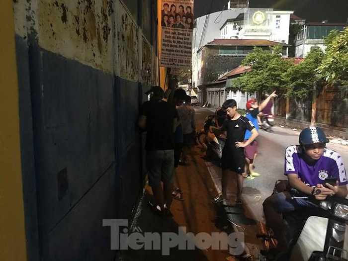 Bên cạnh việc xem máy chiếu, nhiều CĐV Hà Nội vẫn muốn theo dõi trực tiếp bóng đá và cách họ chọn đó là nhìn qua kẽ hở ở cánh cửa sắt SVĐ Hàng Đẫy. Ảnh: Tiền Phong