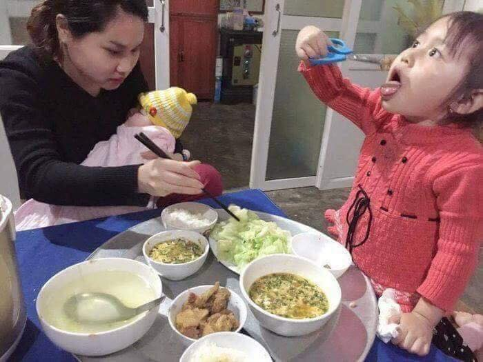 Một tay ôm con bé, tay kia ăn cơm còn mắt thì lại để ý đến đứa con lớn là điều mà không ít các chị em "đẻ dày" gặp phải.