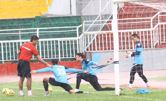 Ở phía gần cầu môn, HLV thủ môn Võ Văn Hạnh đã cho các thủ môn khởi động giãn cơ bằng những bài tập với dây chun.