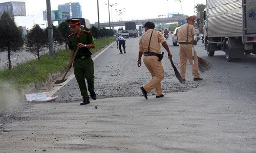 Các chiến sĩ CSGT TP Cần Thơ mượn chổi, xẻng để quét từng viên đá giúp dân