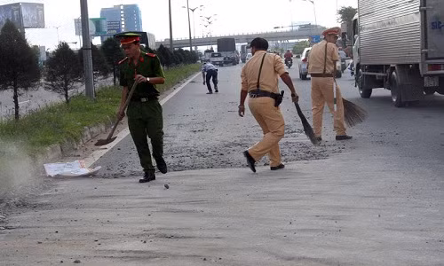 Các chiến sĩ CSGT TP Cần Thơ mượn chổi, xẻng để quét từng viên đá giúp dân