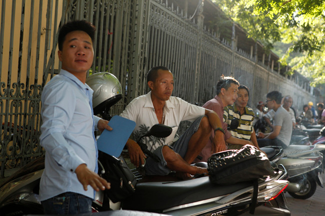 Một số cô chú còn đứng hẳn lên bậc tường để nhìn vào trong sân, mong ngóng con mình từng phút một.