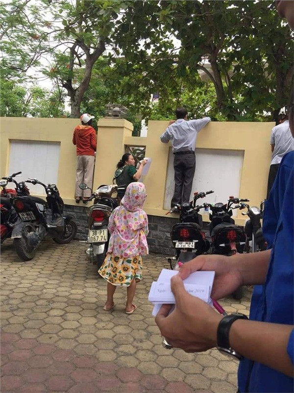 Ở một góc khác của kỳ thi vào THPT, những bậc phụ huynh đứng ngồi không yên bên ngoài cổng trường.