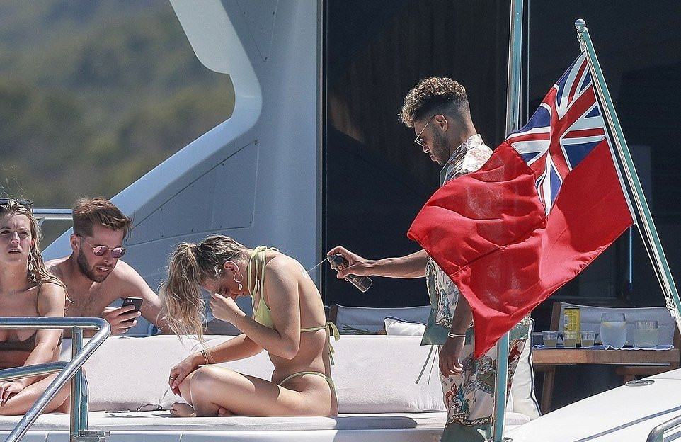 Anh giúp bạn gái thoa kem chống nắng.