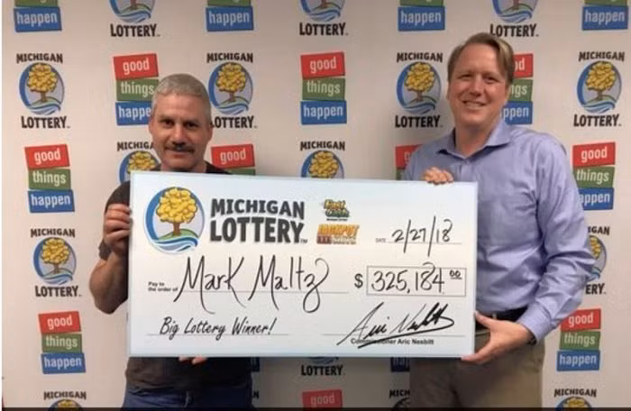 Ông Mark Maltz (trái) nhận giải thưởng xổ số 325.184 USD ngày 27/2.