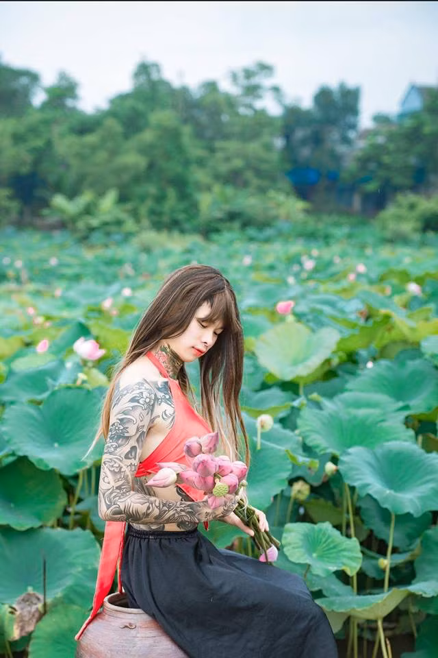 Góc ảnh dịu dàng của Tuấn Lâm trong áo yếm, bên hồ sen.