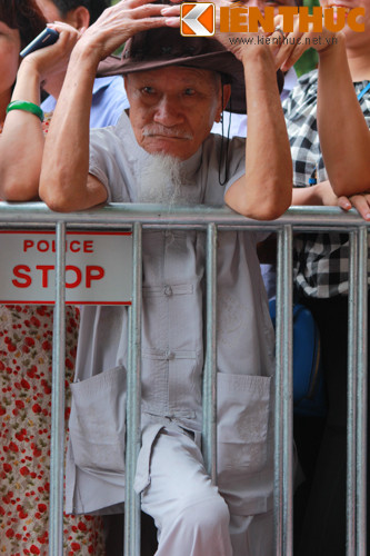 Một cụ già hồi hộp chờ đợi đoàn diễu binh đi qua.