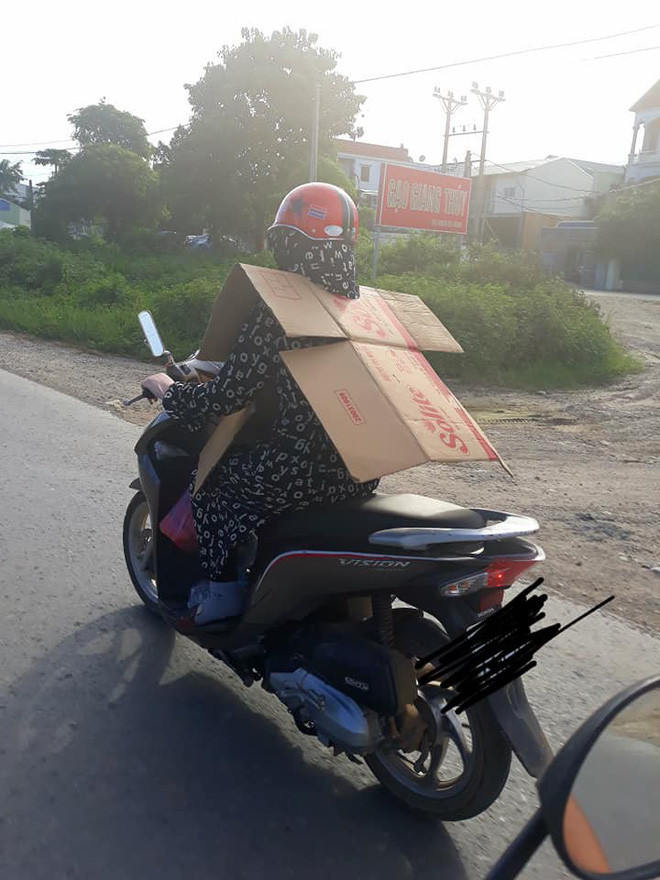 Ngoài việc "ngụy trang" siêu kín bằng áo chống nắng, quần chống nắng, tất, khẩu trang, kính râm thì người phụ nữ đi xe máy này còn mặc nguyên "chiếc áo giáp" bằng bìa cát-tông để đối chọi với cái nắng nóng.