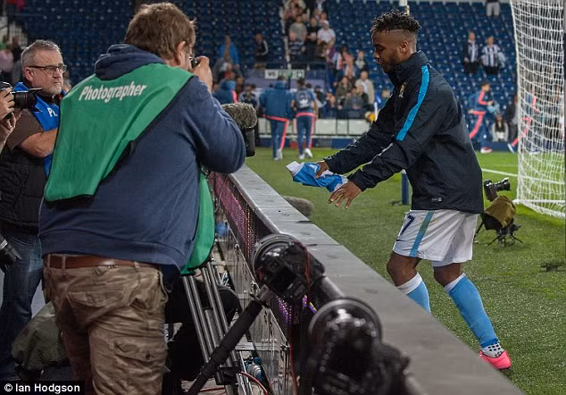  Chàng tiền đạo của Man City nhảy qua bảng điện tử trên sân The Hawthorns để tiến đến khán đài.