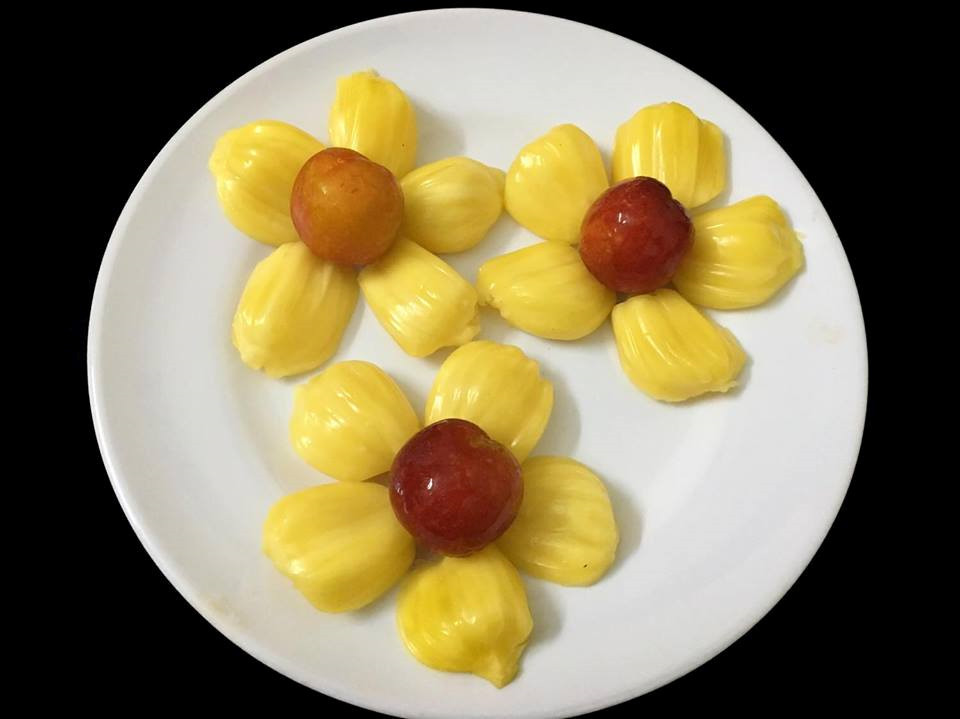 Không quá cầu kỳ, tất cả những gì bạn cần là một chiếc đĩa tròn trắng. Múi mít bỏ hạt, chia đôi xếp úp chồng lên nhau tạo thành hình hoa. Bạn có thể chọn một quả mận nhỏ xinh hoặc bất kỳ quả gì bạn thích làm nhụy hoa.