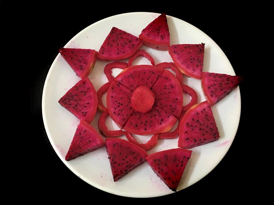 Thanh long xếp thành hình hoa không hề khó. Bạn vẫn cắt thanh long thành từng khoanh và chia thành các miếng tam giác. Sau đó, xếp phần nhụy hoa là một khoanh riêng, các miếng tam giác chia ra các bên. Phần vỏ thanh long thừa có thể làm lớp hoa thứ hai để trang trí cho đĩa hoa quả bắt mắt hơn.