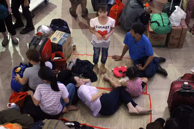 Do bên trong quá tải nên nhiều người ra ngoài sân ga trải chiếu nằm nghỉ ngơi, chờ đợi tới chuyến của mình để về quê.