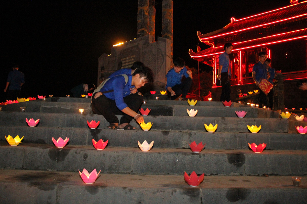 Các bạn thanh niên chỉnh sửa từng cánh hoa đăng rất cẩn thận để chuẩn bị cho màn thả đèn được lung linh nhất.