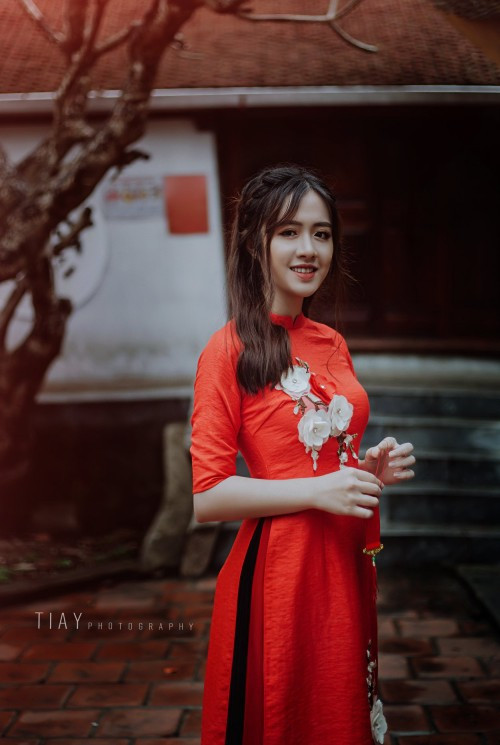 Nhẹ nhàng một bông đào trắng nổi trên nền áo dài đỏ, đơn giản nhưng mang đến bức ảnh có chiều sâu tối đa.