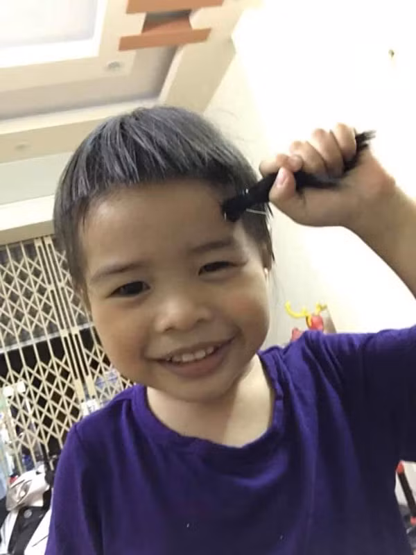 Để thực hiện được kiểu tóc "nhà tranh mái lá", ông bố đã cẩn thận buộc tóc thành hai chùm rồi nhẹ nhàng cầm kéo cắt dứt khoát, ông bố ngay lập tức đã hoàn thành xong nhiệm vụ của mình.