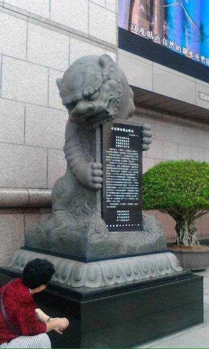 Không chỉ có nhiệm vụ canh nhà, bức tượng sư tử này còn làm nhiệm vụ ôm tấm bảng đá quảng cáo.