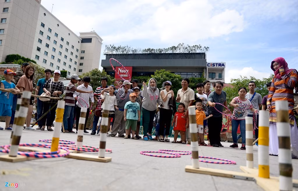 Mặc dù gần về trưa, trời nắng, nhiều người vẫn chờ đợi đến lượt để tham gia trò chơi ném vòng.