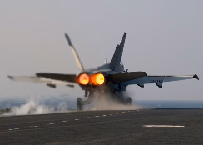 Một chiếc F/A-18C cất cánh khỏi đường băng với 2 động cơ phản lực GE F-404. Các chiến đấu cơ Mỹ thường sử dụng cơ chế đốt nhiên liệu ở phần đuôi nhằm gia tăng lực đẩy toàn phần.