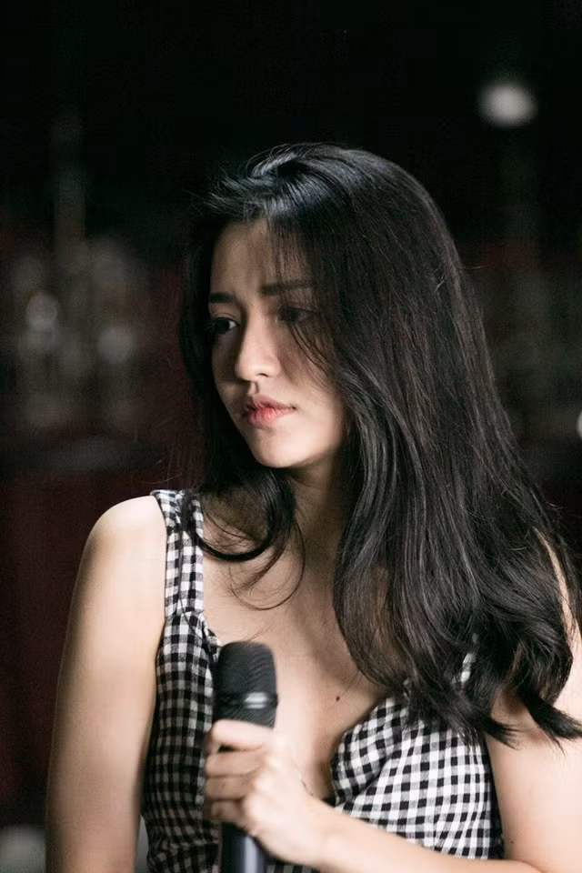 Bích Phương ở bộ hình này không mặc đồ hiệu đắt đỏ, hay những thứ váy áo màu sắc, không làm tóc cầu kỳ, không tô mắt vàng mắt đỏ như trong MV mà trái lại, cô để tóc đen buông xõa, mặc váy 2 dây gingham đơn giản và makeup cũng cực kỳ nhạt.