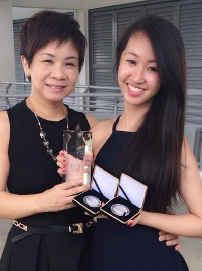 Chelsea Sim khoe những danh hiệu mà mình đã giành được. Bên cạnh cô là mẹ, người mà luôn cổ vũ tinh thần giúp nữ VĐV 9X này vững tâm trên sàn đấu.