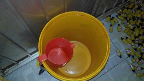 Xô dùng để đựng dung dịch Povidone trước khi cho vào lọ, dán nhãn mác. Ảnh Việt Văn.