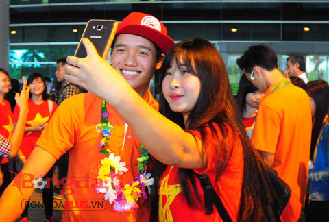 Thủ môn Phí Minh Long tươi cười chụp ảnh với nữ CĐV.