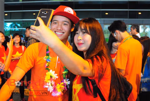 Thủ môn Phí Minh Long tươi cười chụp ảnh với nữ CĐV.