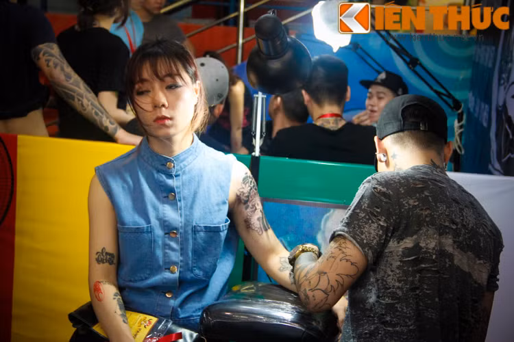 Một có gái xinh đẹp chịu đau để sở hữu hình xăm ấn tượng nơi cánh tay của mình.