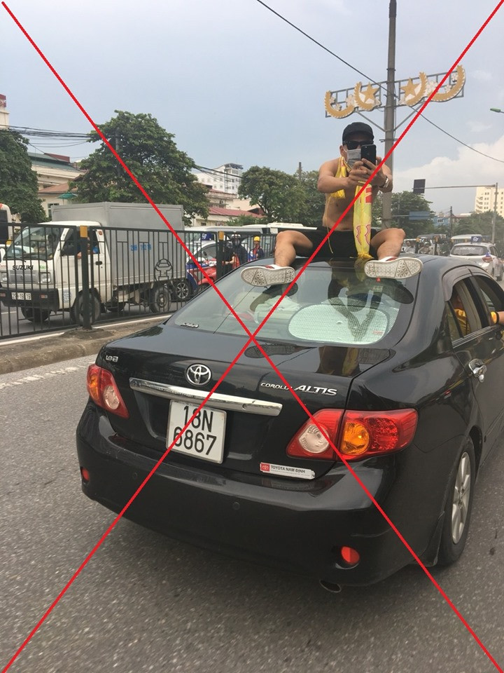 Hình ảnh ngồi lên nóc ô tô di chuyển diễu hành của CĐV Nam Định trên đường phố Hà Nội.