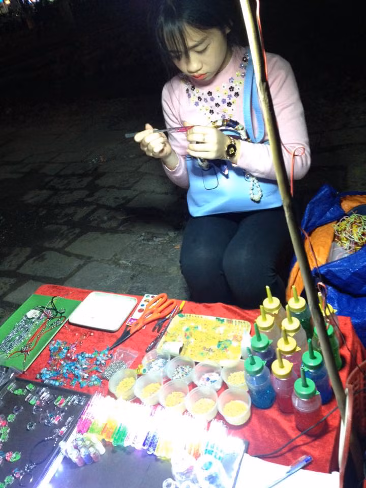 Với khuôn mặt bầu bĩnh, dễ thương, cô chủ hàng lưu niệm khiến nhiều vị khách phải nán lại ngắm nhìn. Nhiều cư dân mạng tiết lộ thêm rằng, cô hot girl này có tên là Tiểu My và hay bán quán gần cầu Trường Tiền (Huế).